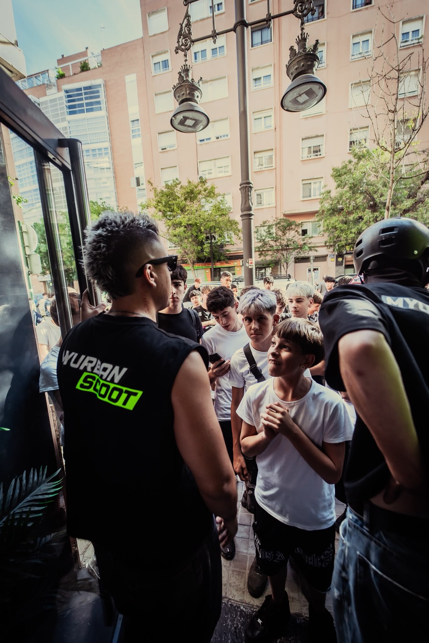 Chavales esperando en la entrada de la tienda MyUrbanScoot de Valencia durante la presentación